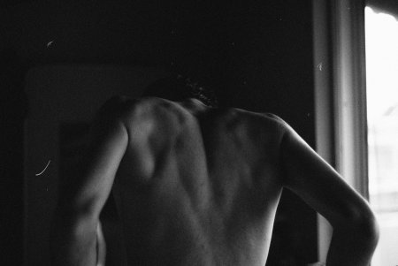 Мужская спина на кровати