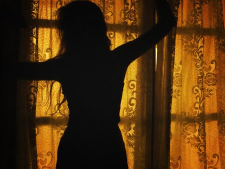 Брюнетка у окна со спины