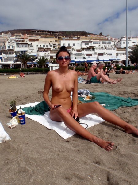 На пляже девушки загорают топлес