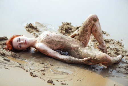 Голые женщины купаются в грязи