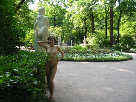 Голая женщина гуляет в парке