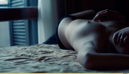 Голая в кровати в темноте