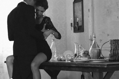 Мужчина обнимает женщину на столе