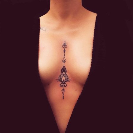 Тату между грудью женская