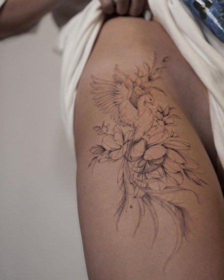 Женская татуировка на бедре