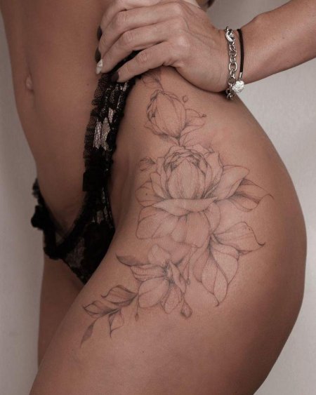 Женская татуировка на бедре