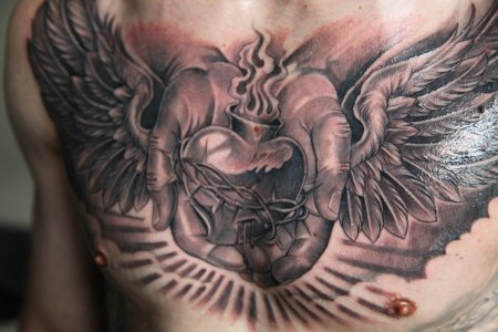 Тату сердце с крыльями на груди