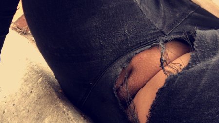 Попа в рваных джинсах