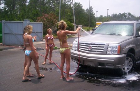 Девушка моет машину в купальнике