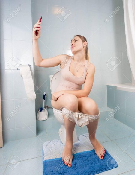 Женщина сидит на унитазе