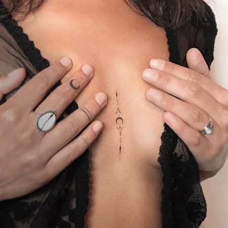 Татуировка между грудей