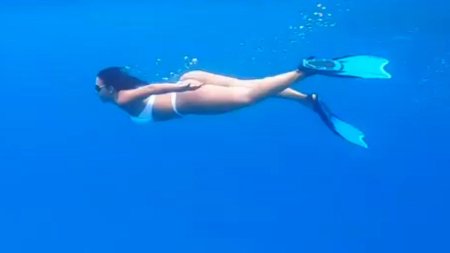 Девушка в ластах под водой