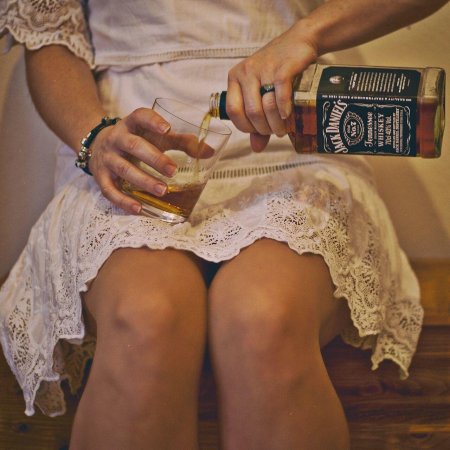 Красивая девушка с бутылкой виски