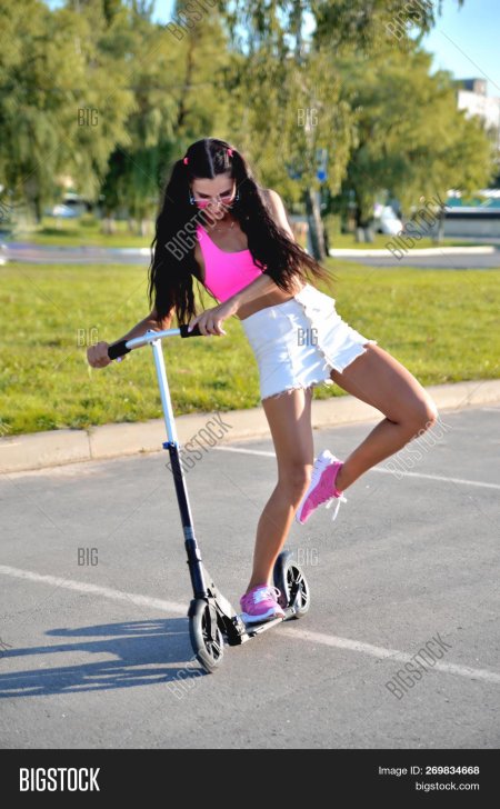 Девушка брюнетка на самокате