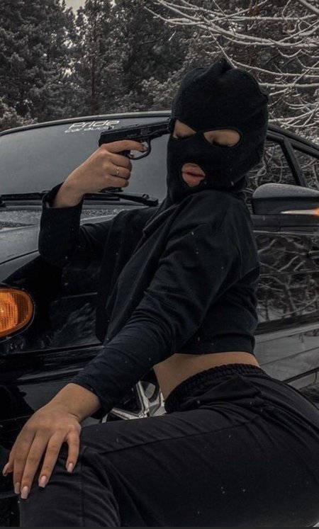 Девушка в балаклаве с оружием