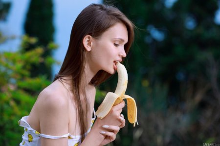 Девушка ест банан