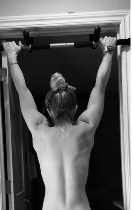 Девушка подтягивается на турнике