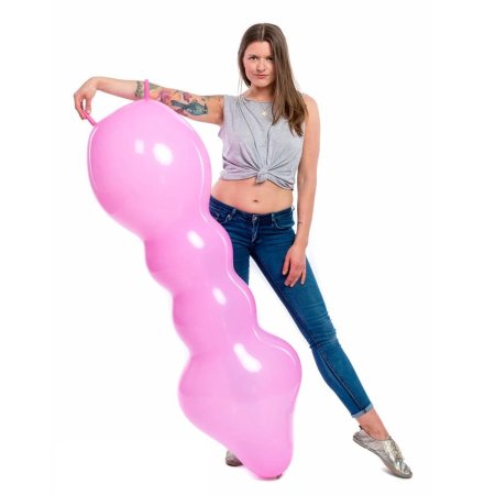 Девушка надувает воздушный шарик