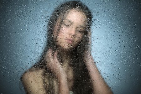 Девушка за мокрым стеклом