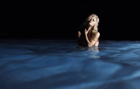 Девушка купается в море