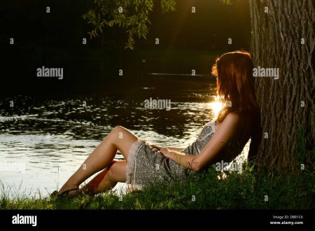 Девушка прислонилась спиной к дереву