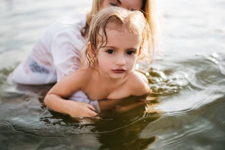 Мама с дочкой купаются в реке