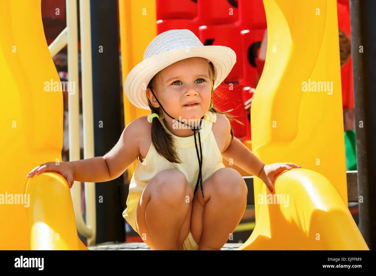 Девочка на корточках на детской площадке