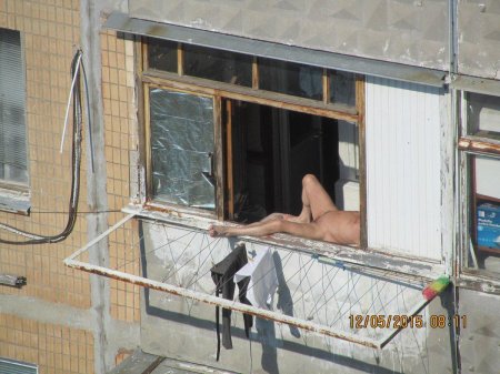 Девушка загорает в окне