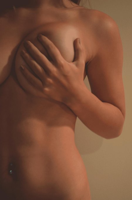 Девушка прикрывает грудь одной рукой