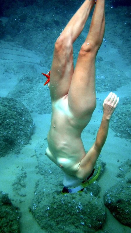 Плавает под водой голышом